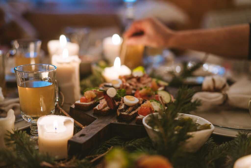 A cozy holiday dinner setting featuring candles, festive food, and a warm atmosphere.
